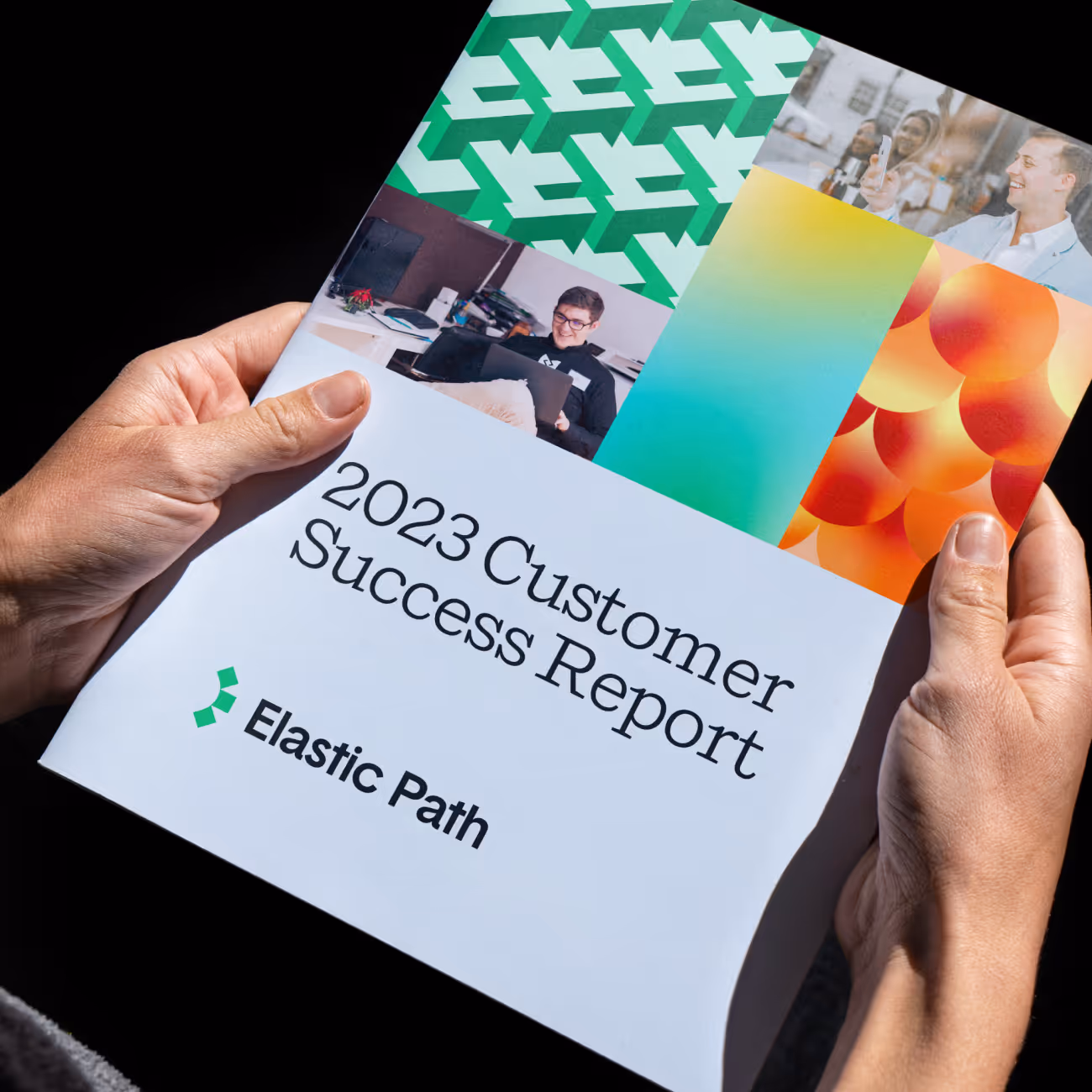 Hands holding a booklet titled '2023 Customer Success Report' by Elastic Path with colorful images on the cover.