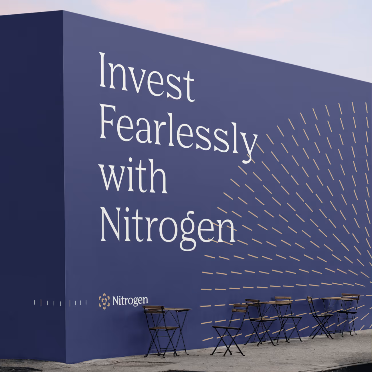 Outdoor seating area with black metal tables and chairs in front of a large dark blue wall displaying the text 'Invest Fearlessly with Nitrogen' and a decorative dashed line pattern.