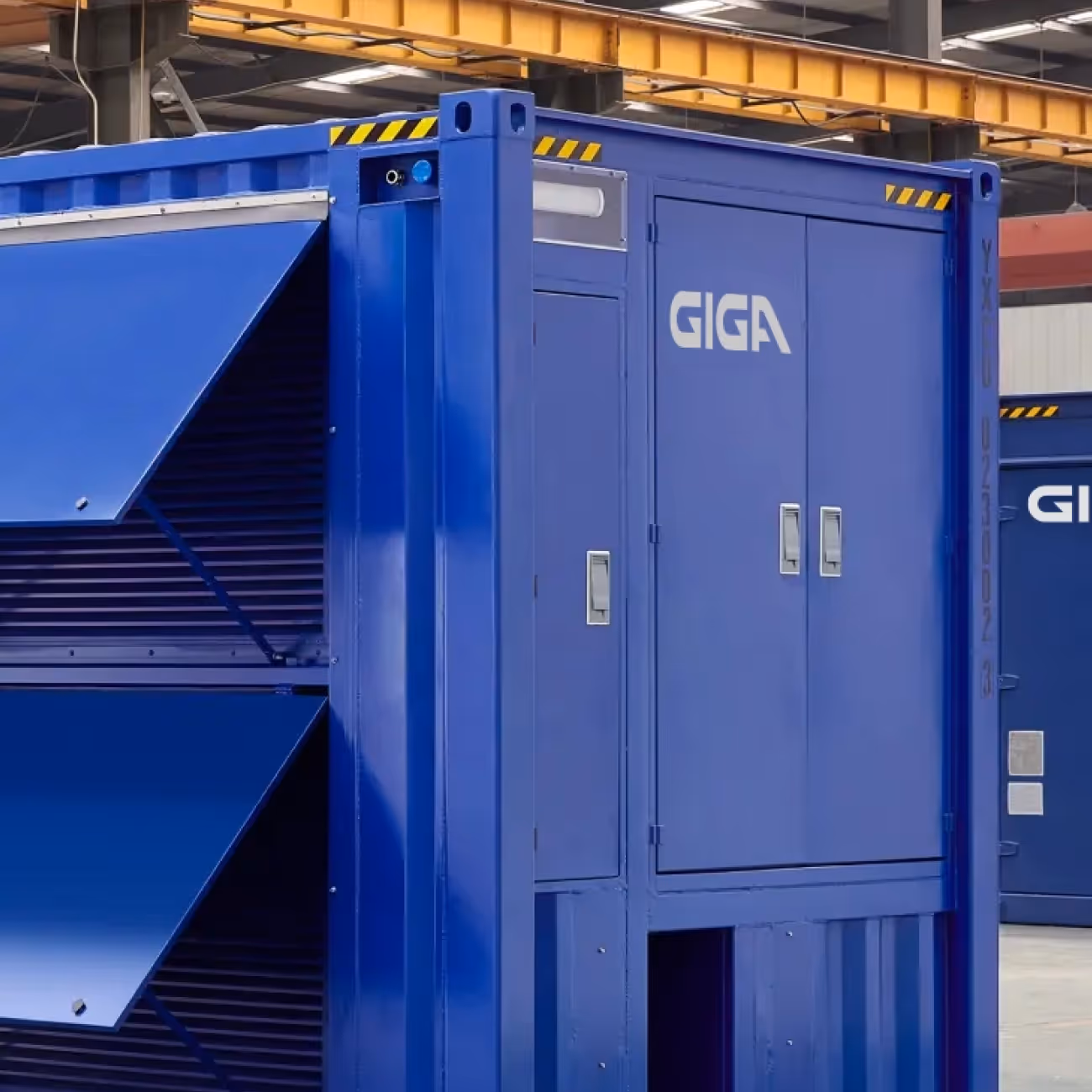Large blue industrial container labeled GIGA inside a warehouse with yellow overhead crane.